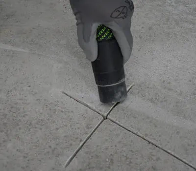 Staub und lose Teile mit dem Absaugmobil aus den Rissen entfernen