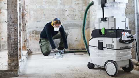 Ein Handwerker schleift einen Boden ab und verwendet das Festool Bodenschleifen System mit Absaugung.