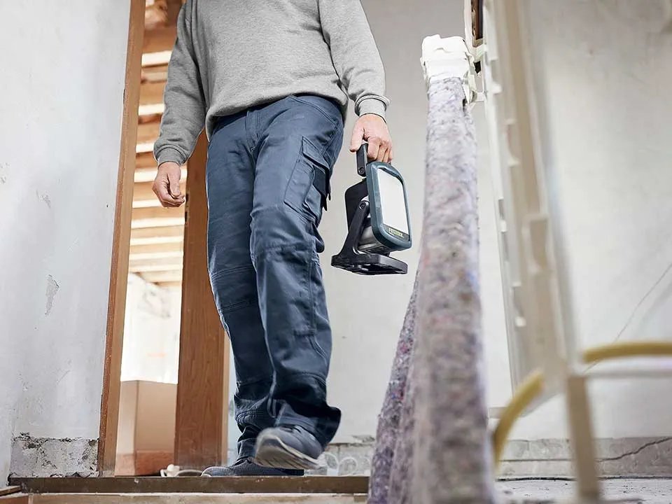 Ein Handwerker trägt einen Baustrahler