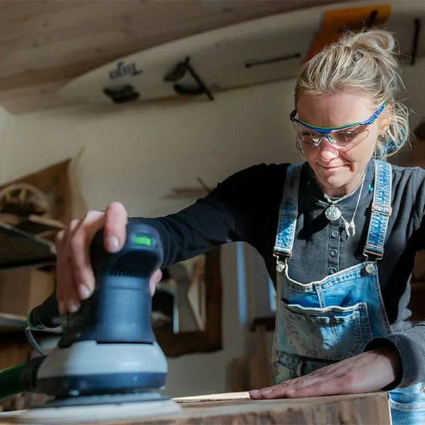 Die Holzbalken werden mit dem Festool Einhandhobel bearbeitet