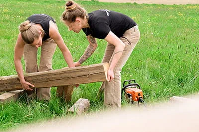 Zwei Schreinerinnen begutachten das Holz für das nächste Projekt