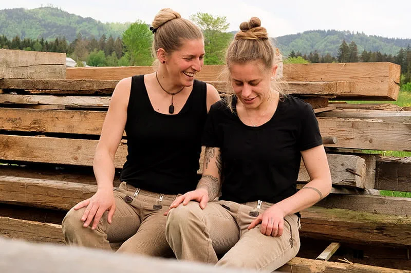 Zwei Schreinerinnen begutachten das Holz für das nächste Projekt