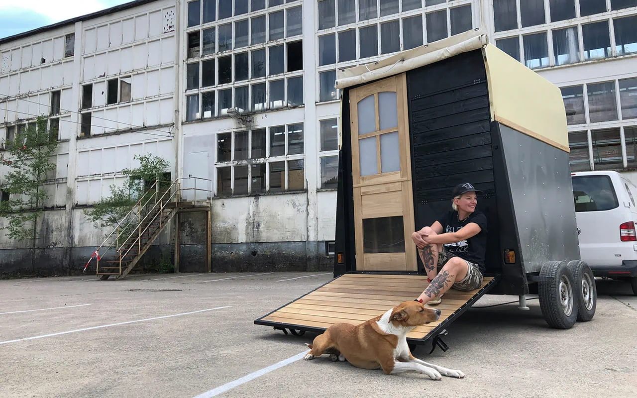 Die Makerin Laura Kampf sitzt mit ihrem Hund Smudo auf einem Anhänger.
