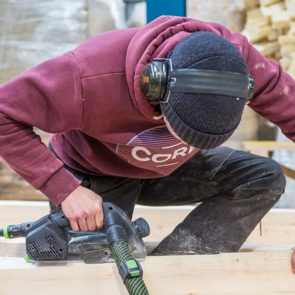 Die Holzbalken werden mit dem Festool Einhandhobel bearbeitet
